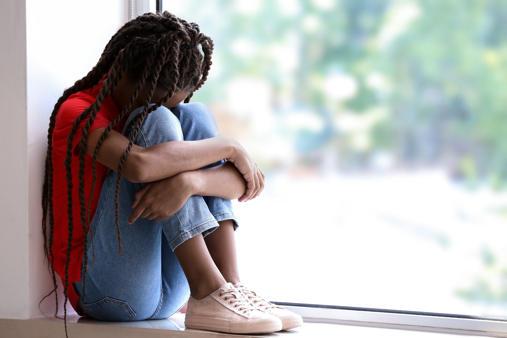 Sad Child Sitting on Windowsill